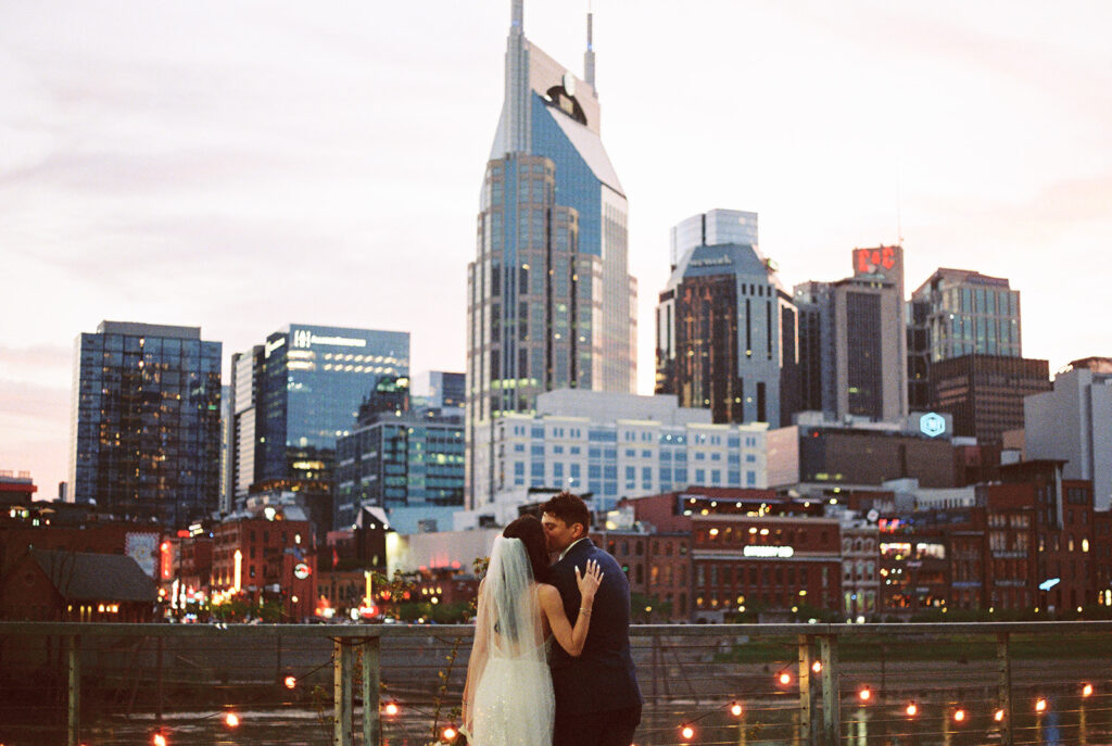 Couple kissing in front of the Nashville skyline
