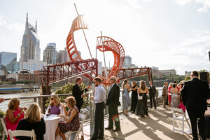 Wedding guests mingling at an outdoor wedding venue overlooking the water
