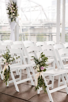 White Ceremony Setup on Rooftop with Floral Arrangements on Aisle Seats {{brizy_dc_image_alt imageSrc=