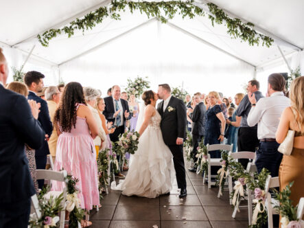 Carissa and Jarrod share a kiss at end of Ceremony Aisle {{brizy_dc_image_alt imageSrc=