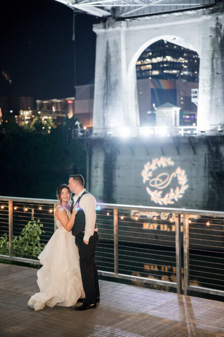 Carissa and Jarrod Outside with Their Custom Gobo on the Bridge {{brizy_dc_image_alt imageSrc=