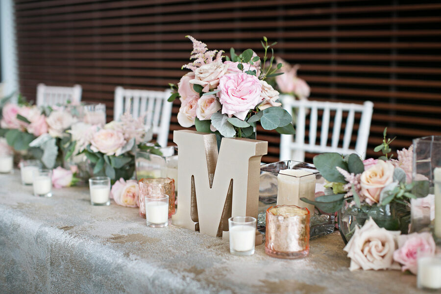 Glam pink wedding table decor with gold textured linens, abundant rose centerpiece arrangements, and votive candles at The Bridge Building, downtown Nashville wedding venue {{brizy_dc_image_alt imageSrc=