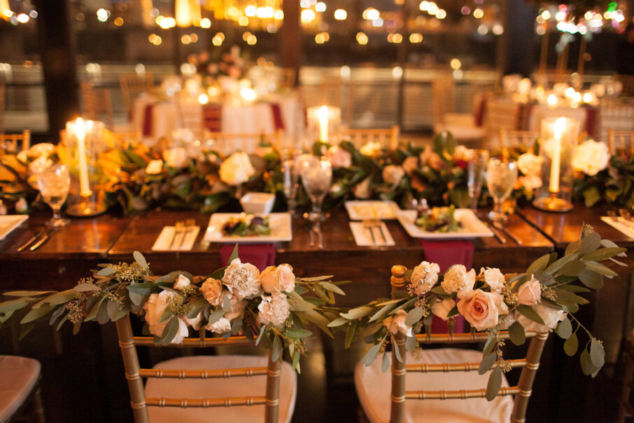 The bride and groom's chairs decorated with greenery and pink and ivory flower arrangements for romantic winter wedding at The Bridge Building, downtown Nashville wedding venue {{brizy_dc_image_alt imageSrc=
