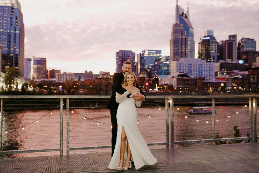 Haley and Andrew on the riverfront with downtown Nashville {{brizy_dc_image_alt imageSrc=