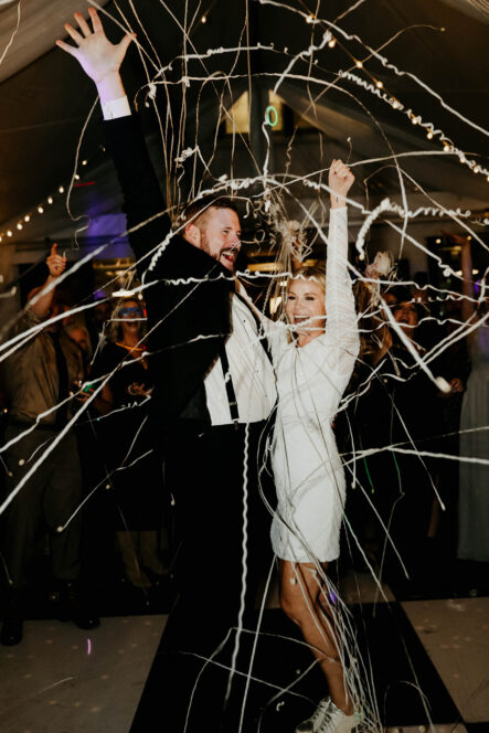 Haley and Andrew celebrate with white streamers after wedding day {{brizy_dc_image_alt imageSrc=