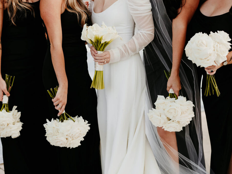 Haley and Her Bridesmaids in Matching Black Dresses with White Bouquets {{brizy_dc_image_alt imageSrc=