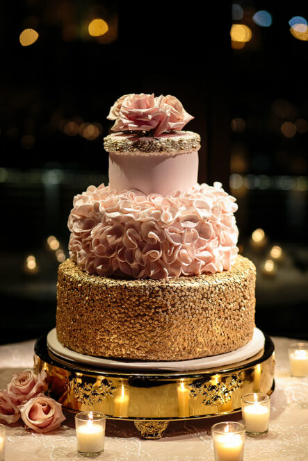 Unique wedding cake with different style tiers with gold beads, pink ruffle icing, and topped with baby pink roses for rose gold New Year's Eve wedding at the Bridge Building, a downtown Nashville wedding venue {{brizy_dc_image_alt imageSrc=