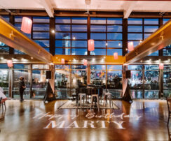 A birthday party set in our private event venue with paper lanterns and grand piano in the Cumberland space with a gobo light that reads {{brizy_dc_image_alt imageSrc=