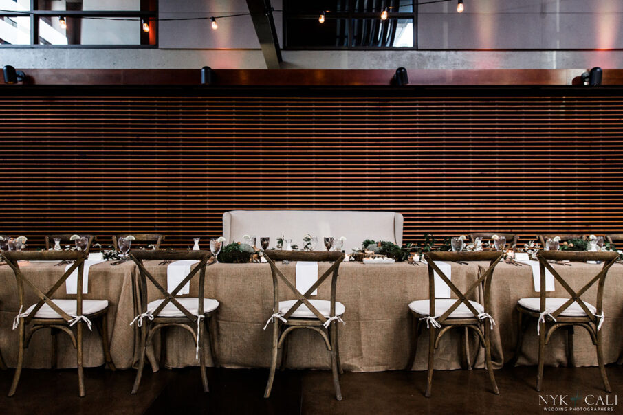 Farmhouse head table with burlap linens and dried greenery runner for nautical themed rehearsal dinner