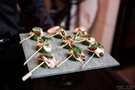 A cater waiter holding a tray of mini tacos